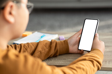 Over shoulder shot of chubby boy using smartphone, mockup