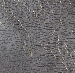 Cracked leatherette on the armchair as a backdrop.