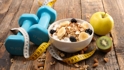 health food concept- muesli,  fruits and dumbbell