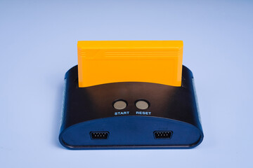 Old retro video game console with cartridge. Isolated on blue background. Copy space text.