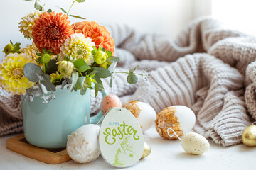 Easter composition with a bouquet of flowers and eggs on a blurred background.