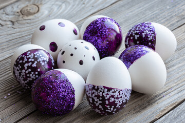 Close-up of Easter eggs decorated with purple sparkles.