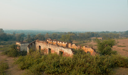 Eerie view of the damaged houses, with collapsing brick walls encroached by weeds, in totally...