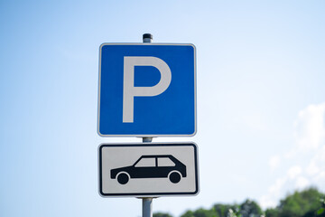 Blue and white parking lot sign with P letter and pictured car in the parking lot - obrazy, fototapety, plakaty