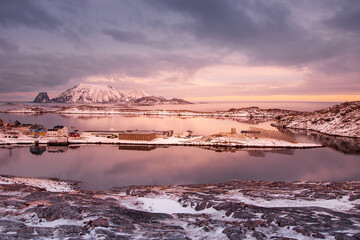Fishing village in norwegian fjords in north cape with snowy mountains