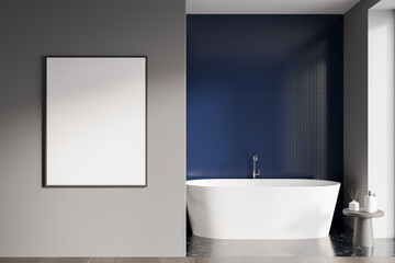 Modern bathroom interior with white ceramic bathtub. Blue tile on walls, hardwood flooring. Blank framed poster on grey wall. Mockup. 3d rendering.