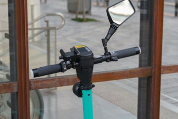 電動キックボードのハンドル部分。安全対策としてバックミラーが付いてる