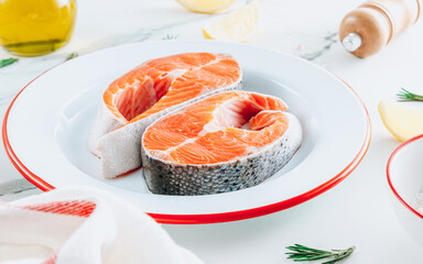 Two fresh salmon steaks on a white plate. Ready for cook