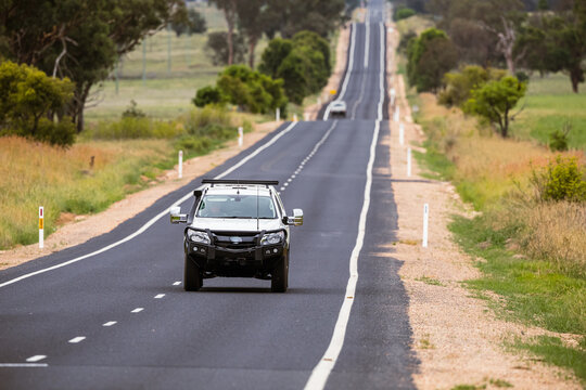Cars on a lonely, long, straight stretch of Australian highway.