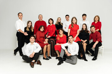 portrait of a large family on a white background. a large friendly family is dressed in red and black clothes. a group of people from different regions of the country. people of different ages