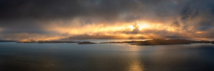 Dramatic panoramic view of Raasay; a group of small islands off the coast of The Isle of Skye in Scotland, UK. Beautiful rays of light breaking through the clouds.