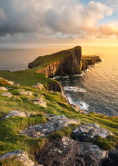 Popular sightseeing destination Neist Point Lighthouse on the beautiful Isle of Skye, Scotland, UK. Scottish coastal landscapes with golden evening light. - 482137820