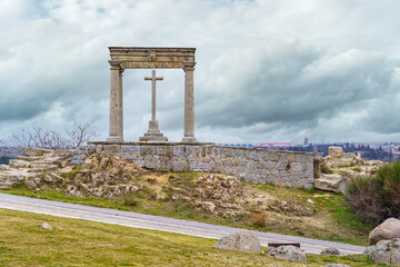 Fototapeta premium Stone cross on a hill overlooking the medieval city of Avila in Spain.