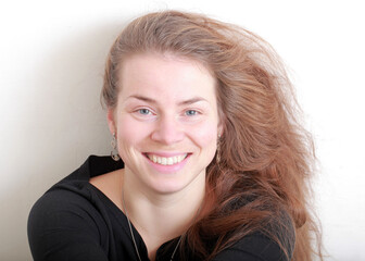 beautiful girl with long hair smiling portrait on a light background