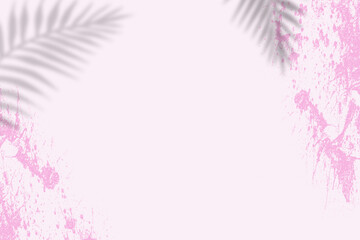 Pink wall with a splash of paint and shadow of a palm leaves.