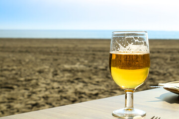 Beer on the table in front of the beach