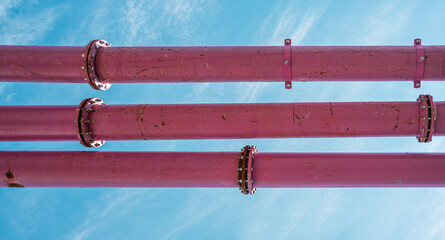 pink water pipes under a blue sky on a construction site in Berlin. Groundwater from excavation pits is pumped away through these pipelines.