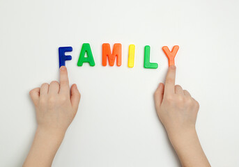The child's hands and the word family made of multicolored letters