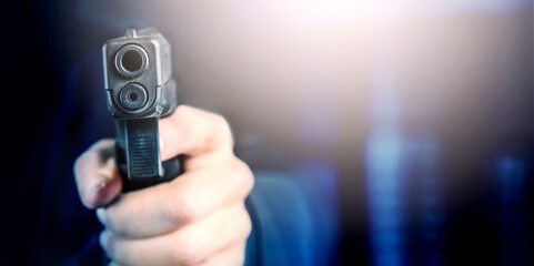 Policeman holding gun in his hand on blur dark subway background. Shooting with a pistol.

