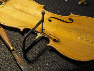 luthier artisan restoring an old italian classic handmade violin in his workshop - specialized craftmanship concept © august.columbo