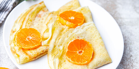 Naklejka na ściany i meble crepes thin pancake citrus Shrovetide holiday Maslenitsa sweet dessert breakfast pancakes healthy meal food snack on the table copy space food background rustic top view