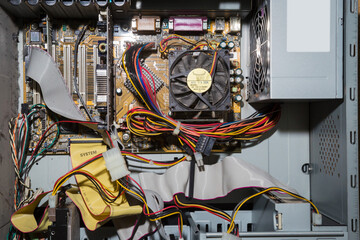Old computer inside. Printed circuit boards, wires, connectors, microchips inside the system unit.