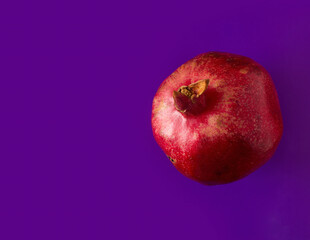 red ripe pomegranate on a purple background