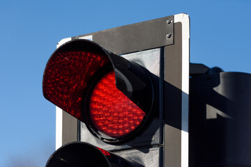 Traffic light with red light against the evening sky.