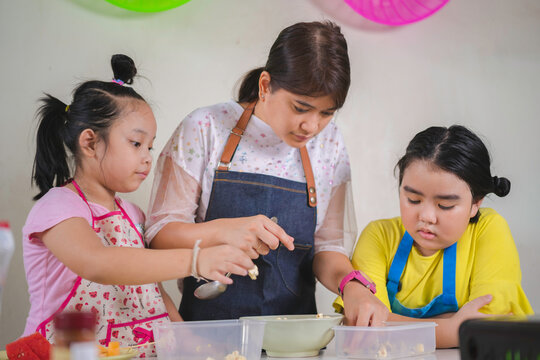 Asian Mother And Daughter Enjoy Making Popcorn