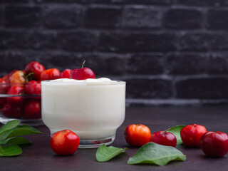 Natural yogurt bowl with a fresh cherry and ripe red cherries on a glass bowl.