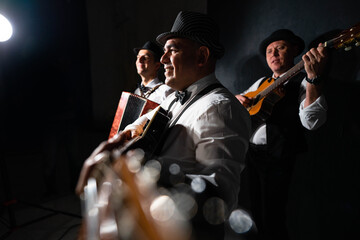Trio of musicians on a black background	