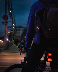 a closeup of a bicycle and a man in the crossing at the night