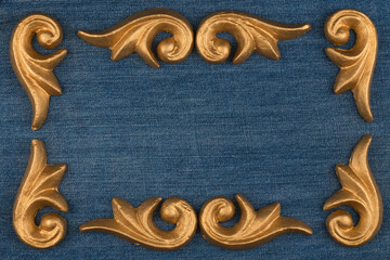 Empty frame made of gold plaster stucco laying on denim - 482155261