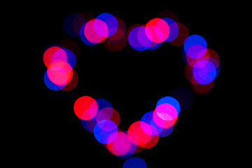 Festive background of multicolored bokeh in the shape of a heart. Abstract blurred colored lights. - 482155263