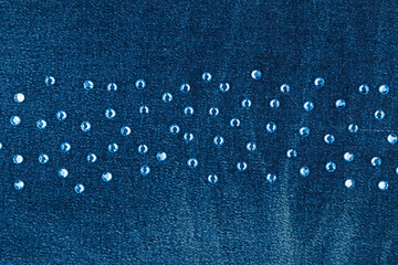 Blue rhinestones lying in a line on worn denim. With space for design, text place. - 482155269