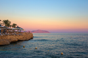 Sunset at luxury tropical resort on Red Sea coast in Sharm el Sheikh, popular resort in Egypt, Africa. Dusk over Sharks Bay. Tourism and travel. Rest and vacation.