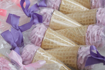 Pink marshmallow in waffle cones. Packed in sachets. Close-up.