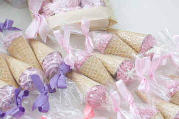 Obraz na płótnie Canvas Pink marshmallow in waffle cones. Packed in sachets. Close-up.