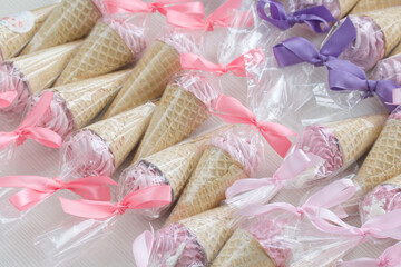Pink marshmallow in waffle cones. Packed in sachets. Close-up.