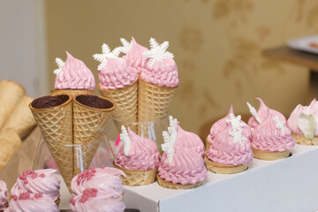 Horns smeared with chocolate from the inside. Placed on a stand. Zephyr in waffle cones. With decorative topping.