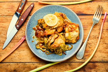 Chicken meat baked with rhubarb,wooden table