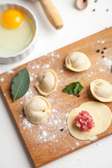 Meat dumplings. Raw dough with minced meat for dumpling on white background 