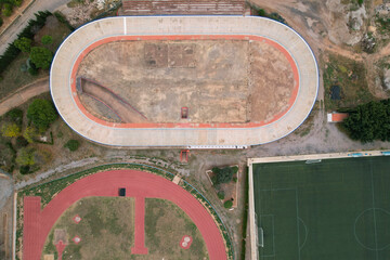 Horizontal top view of a abandoned velodrome next to a running track in Burriana, Spain