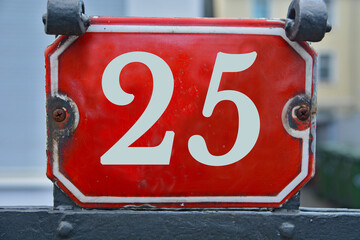 A red number plaque, showing the number twenty-five, 25