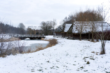 historic thatched wooden houses in skansen in Lublin - winter landscape
