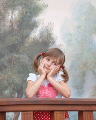 Portrait of a cute pensive girl with pigtails and sly gray eyes