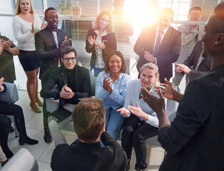 Office employees sit on chairs clap hands greeting presenter or speaker at group meeting close up.