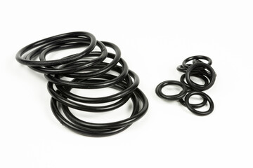 Hydraulic and pneumatic o-rings in black in different sizes on a white background. Various seals...