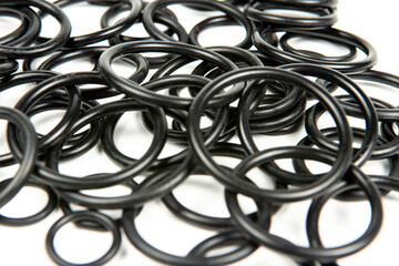 Hydraulic and pneumatic o-rings in black in different sizes on a white background. Various seals...