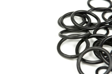 Black hydraulic and pneumatic o-rings in different sizes on a white background. O-rings for hydraulic connections. Rubber seals for sanitary ware. Copy space